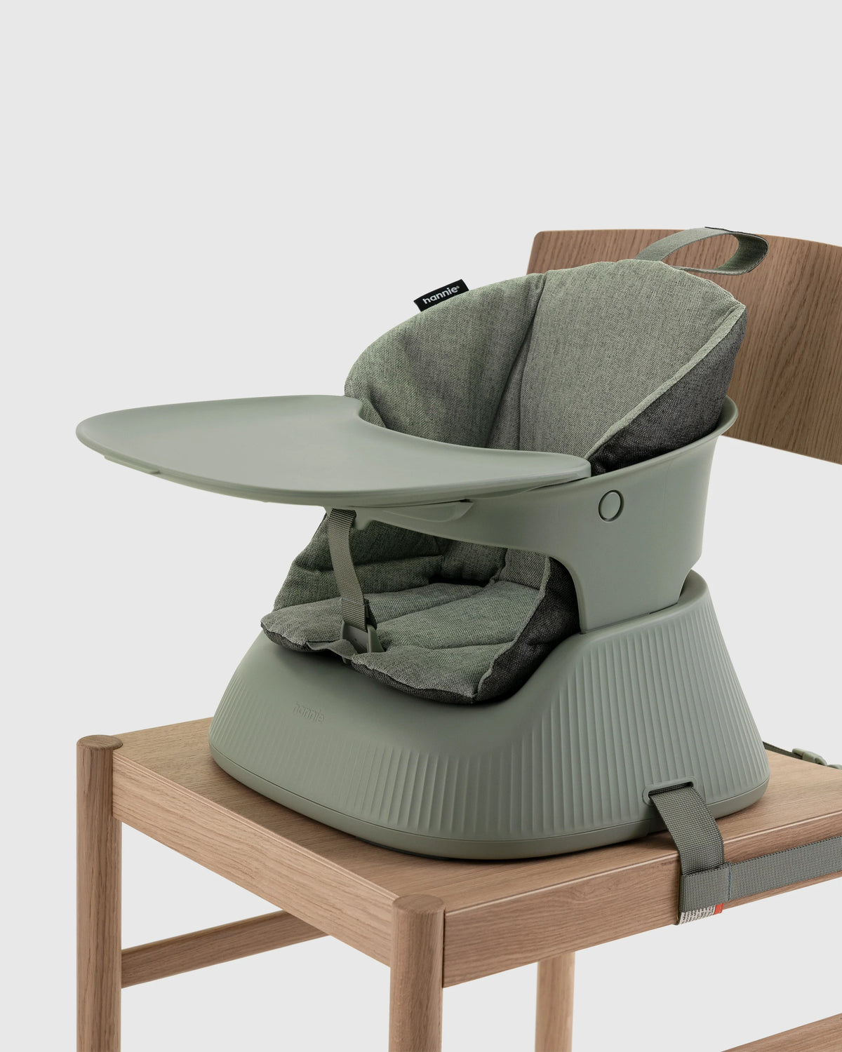 Hannie portable high chair in sage green, lightweight and compact, with adjustable tray and sturdy frame for easy feeding.
